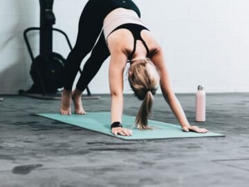 woman in black sports bra and blue denim jeans doing yoga